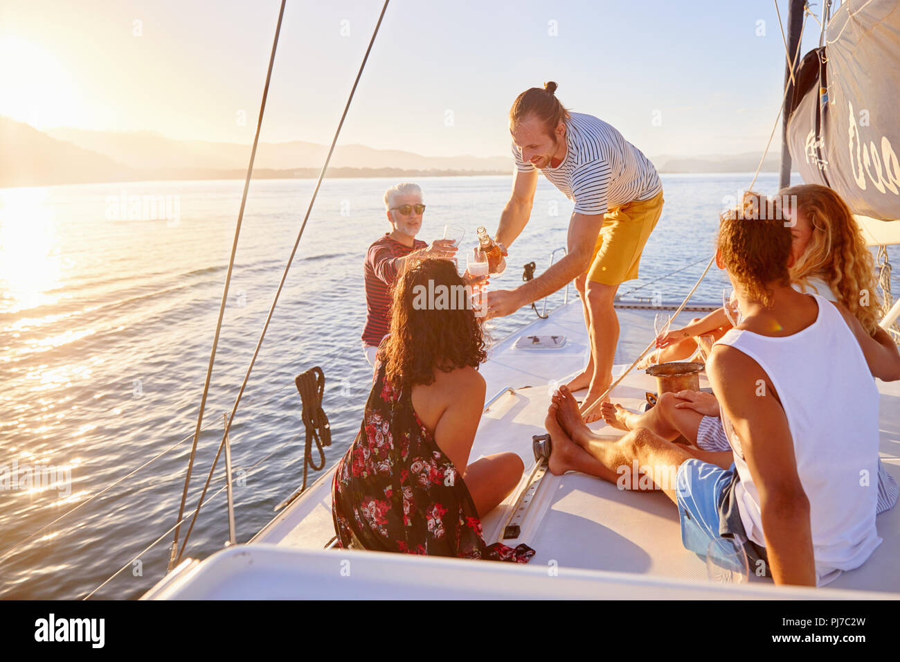 Friends relaxing, drinking champagne on sunny boat Stock Photo