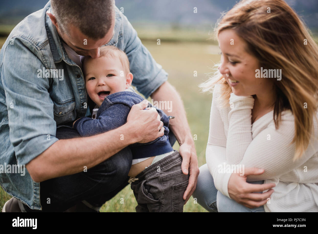 Parents hugging happy baby son Stock Photo
