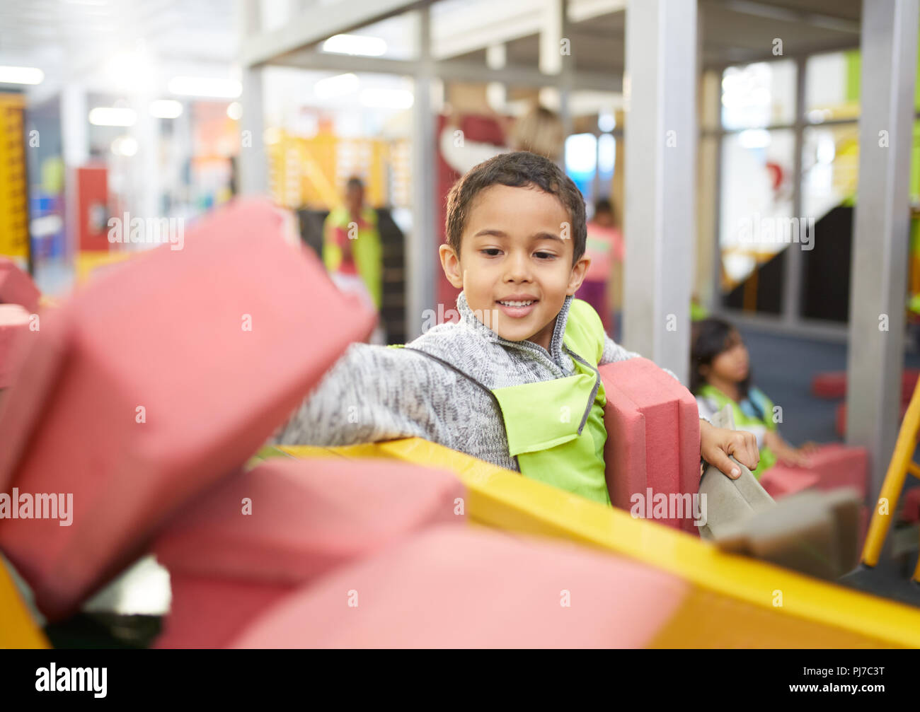 Boy playing at interactive construction exhibit in science center Stock