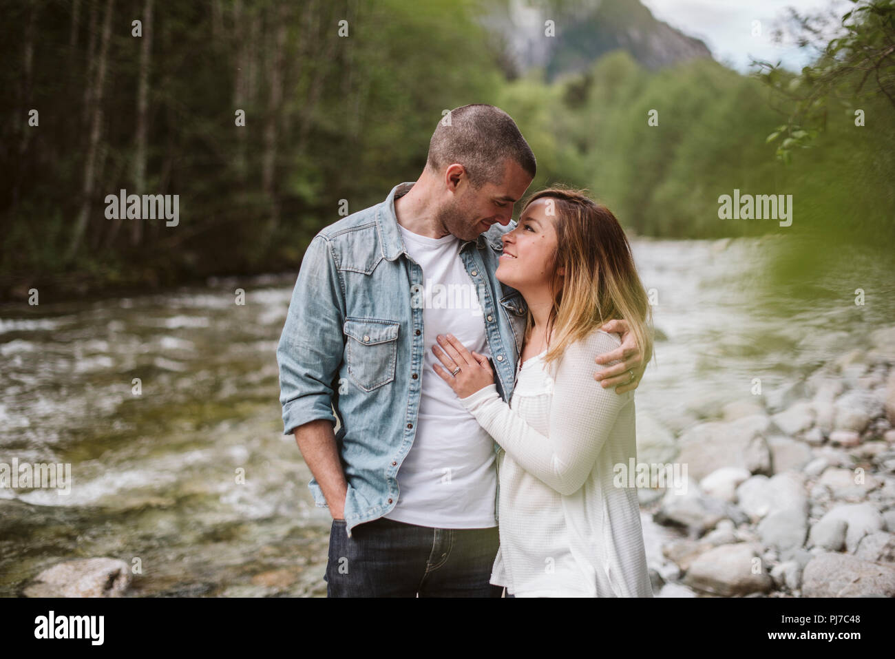 Affectionate couple hugging at riverside Stock Photo