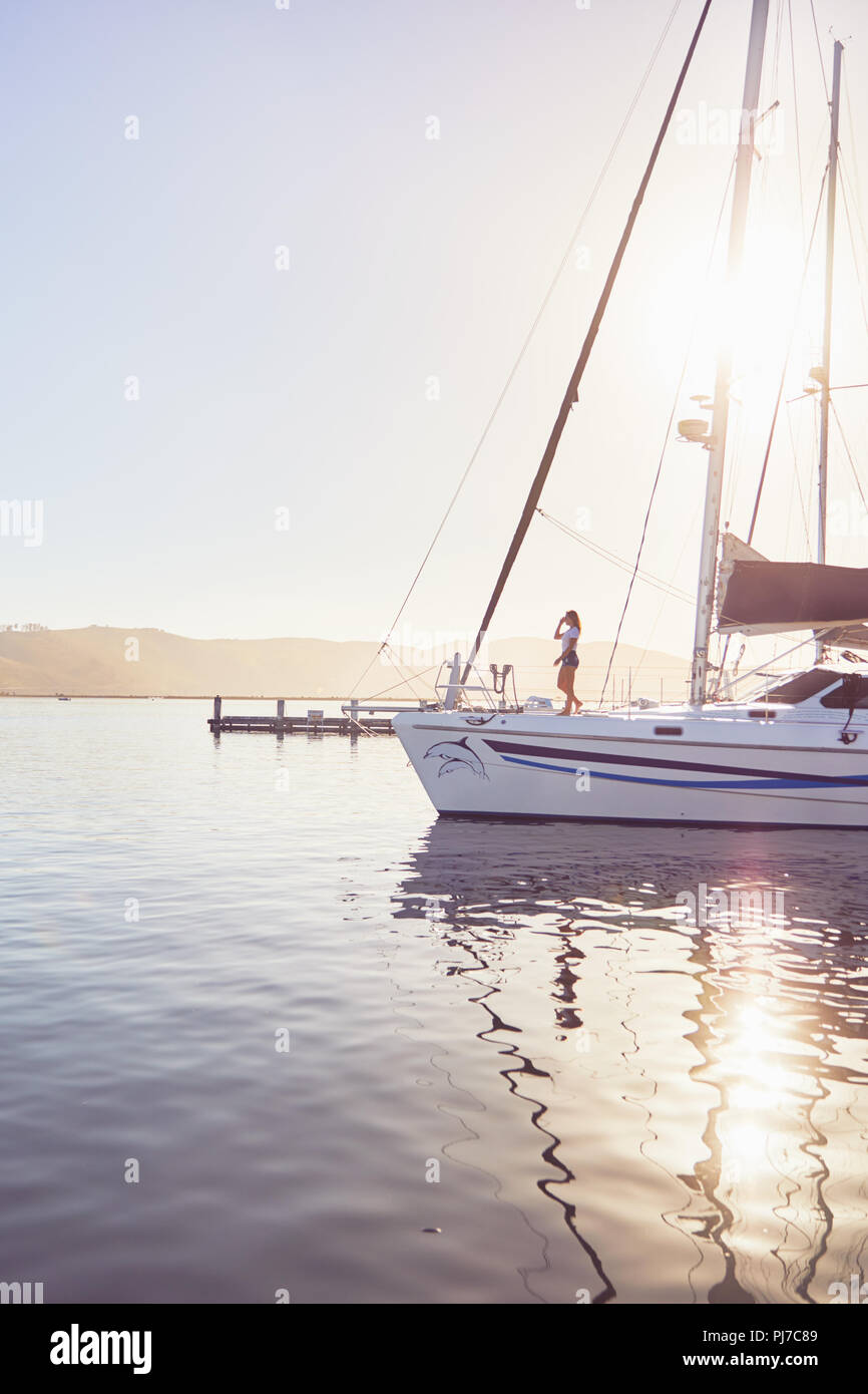 Woman standing on sunny boat in harbor Stock Photo