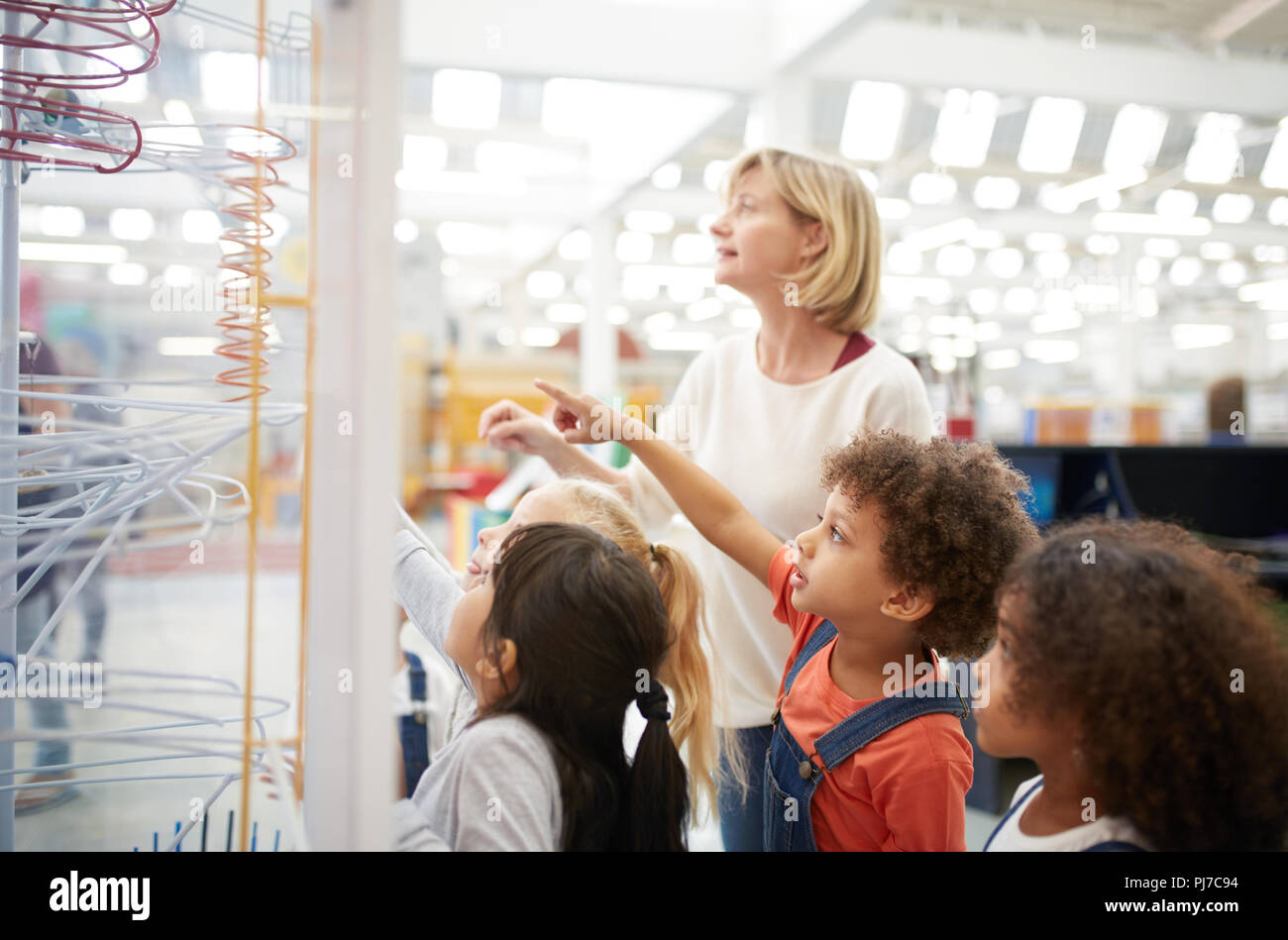 Teacher and curious students watching exhibit in science center Stock Photo