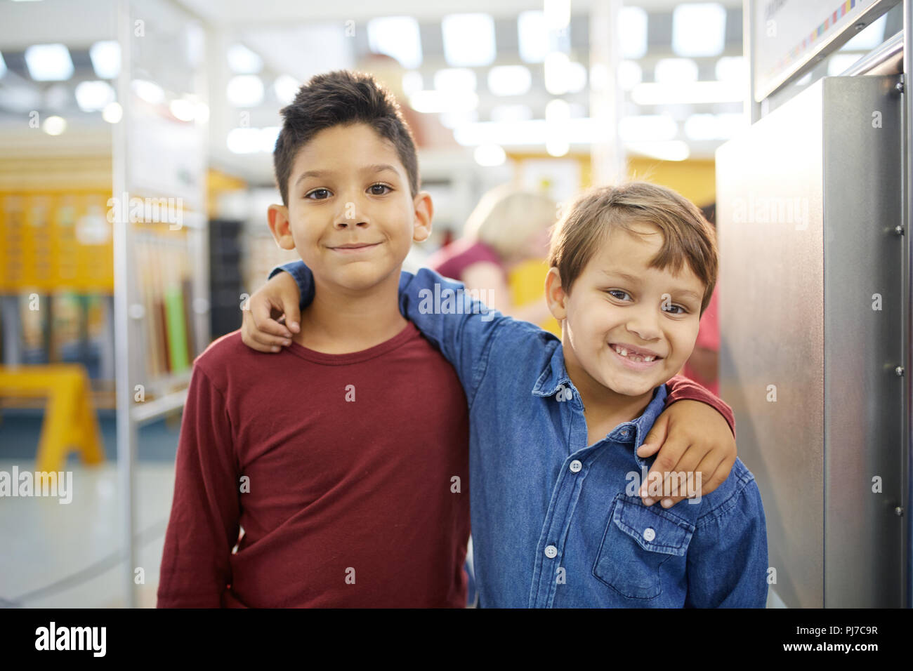 Portrait cute boys hugging in science center Stock Photo - Alamy