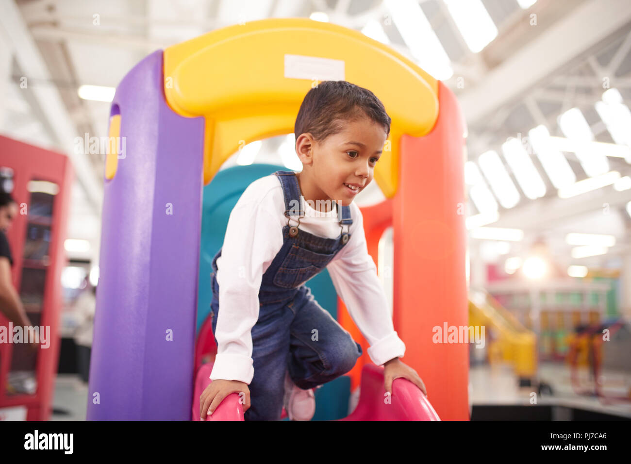 Smiling boy playing on slide Stock Photo