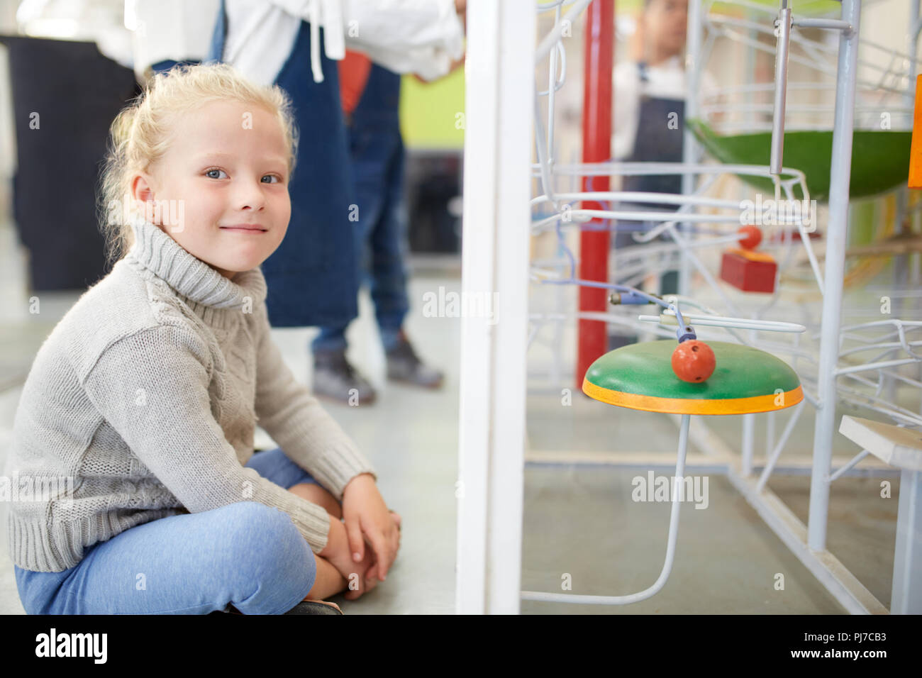 Portrait smiling, confident girl watching exhibit in science center Stock Photo
