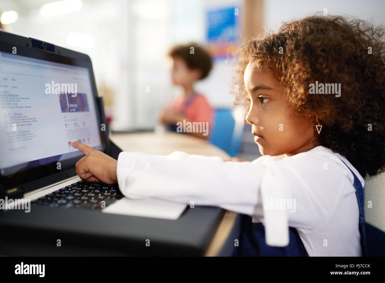 Curious girl using laptop Stock Photo