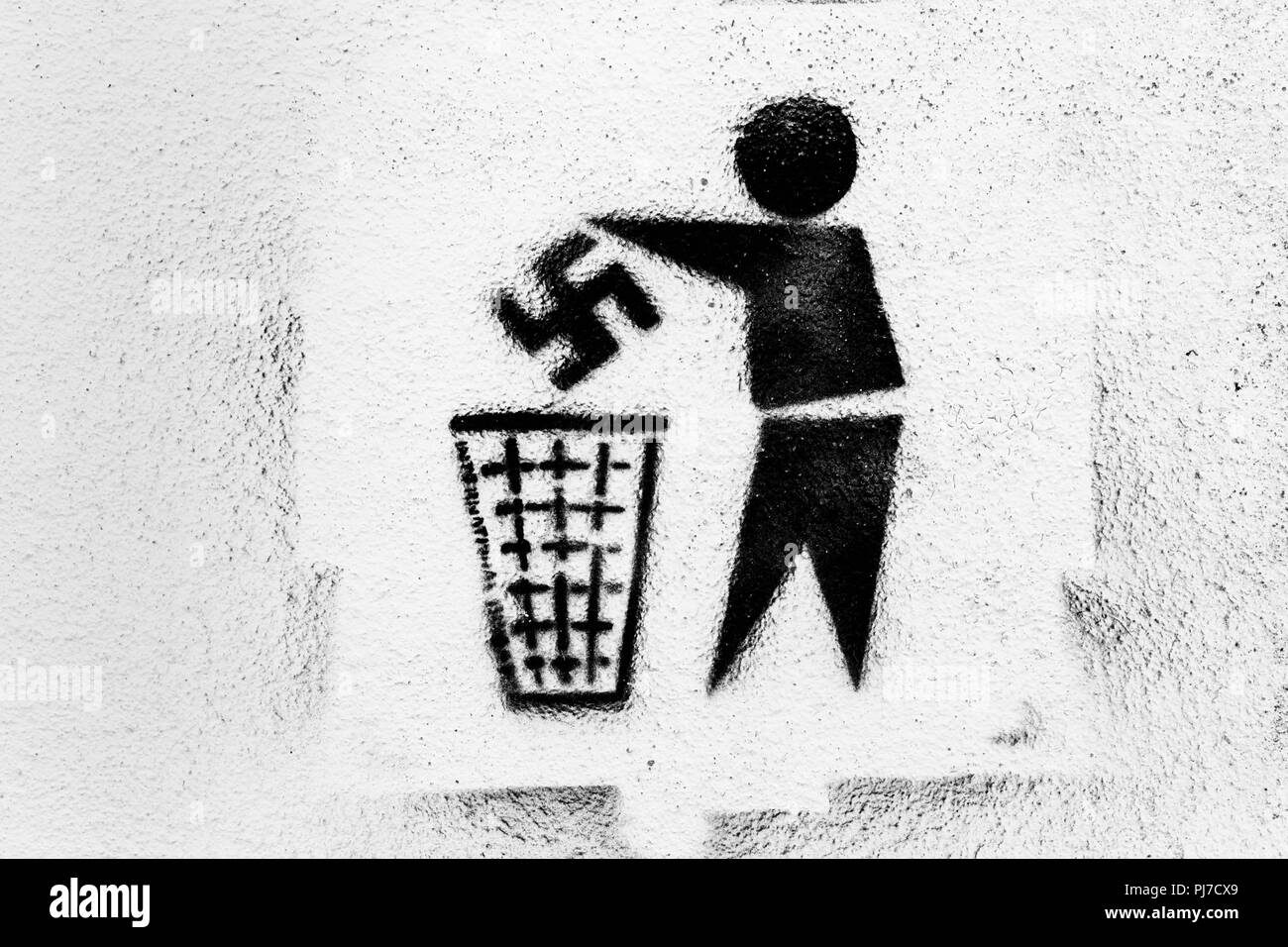 Anti-Nazi graffiti. Swastika being thrown into rubbish bin. Photographed in Tarifa, Spain. Stock Photo
