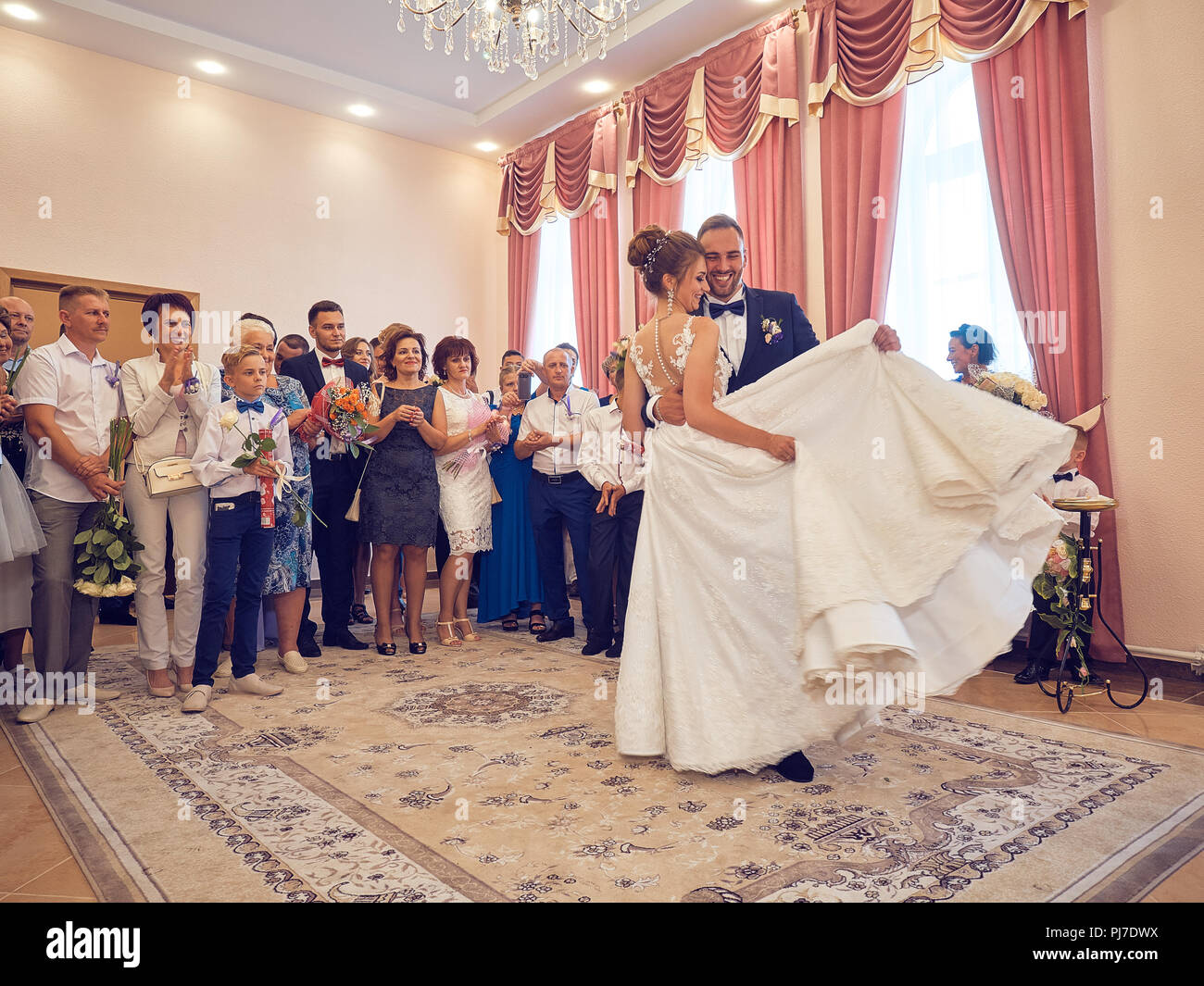 Solemn ceremony of marriage of the newlyweds. Customs and traditions inherited from a past life in the old Soviet Union. People have fun, drinking. Stock Photo