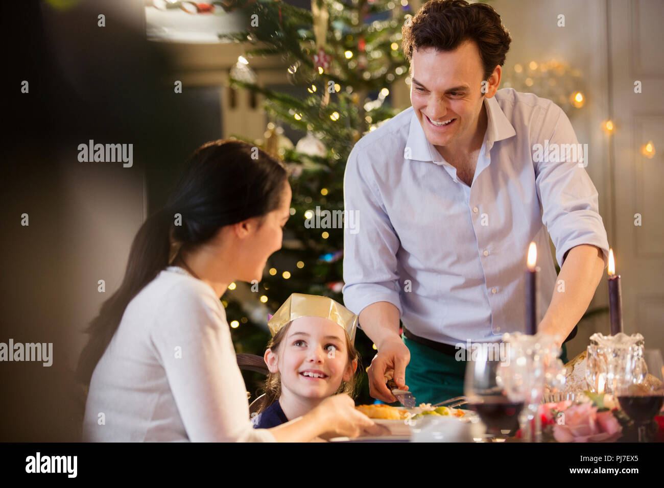 Happy family enjoying candlelight Christmas dinner Stock Photo Alamy