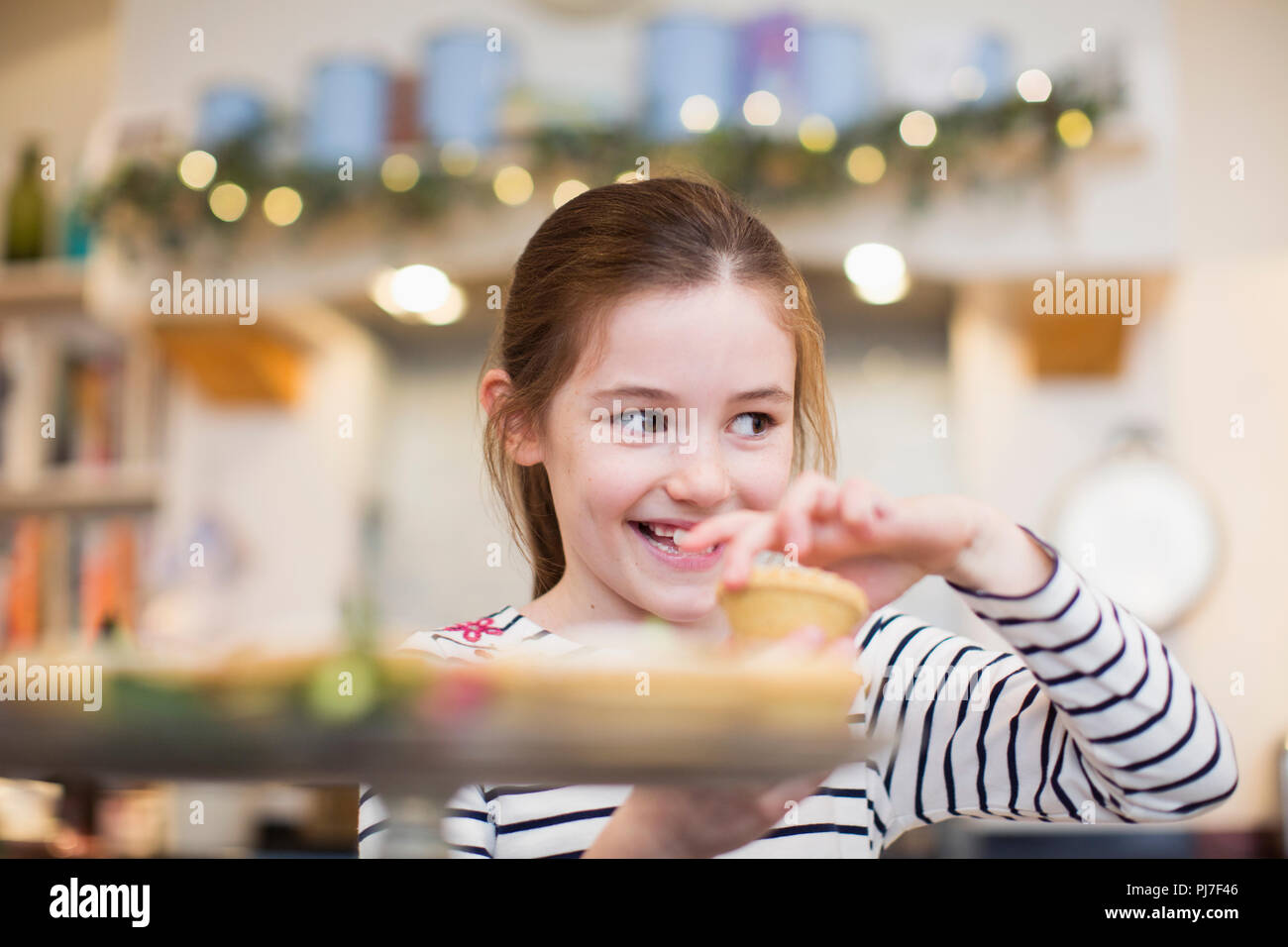 Smiling girl eating Christmas cupcake Stock Photo