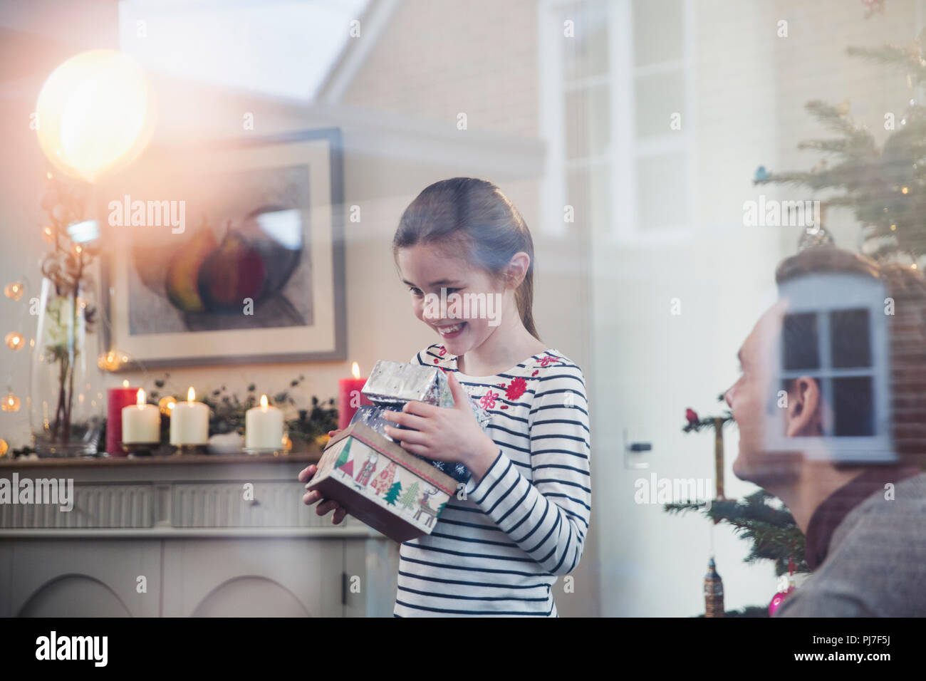 Eager girl gathering Christmas gifts Stock Photo