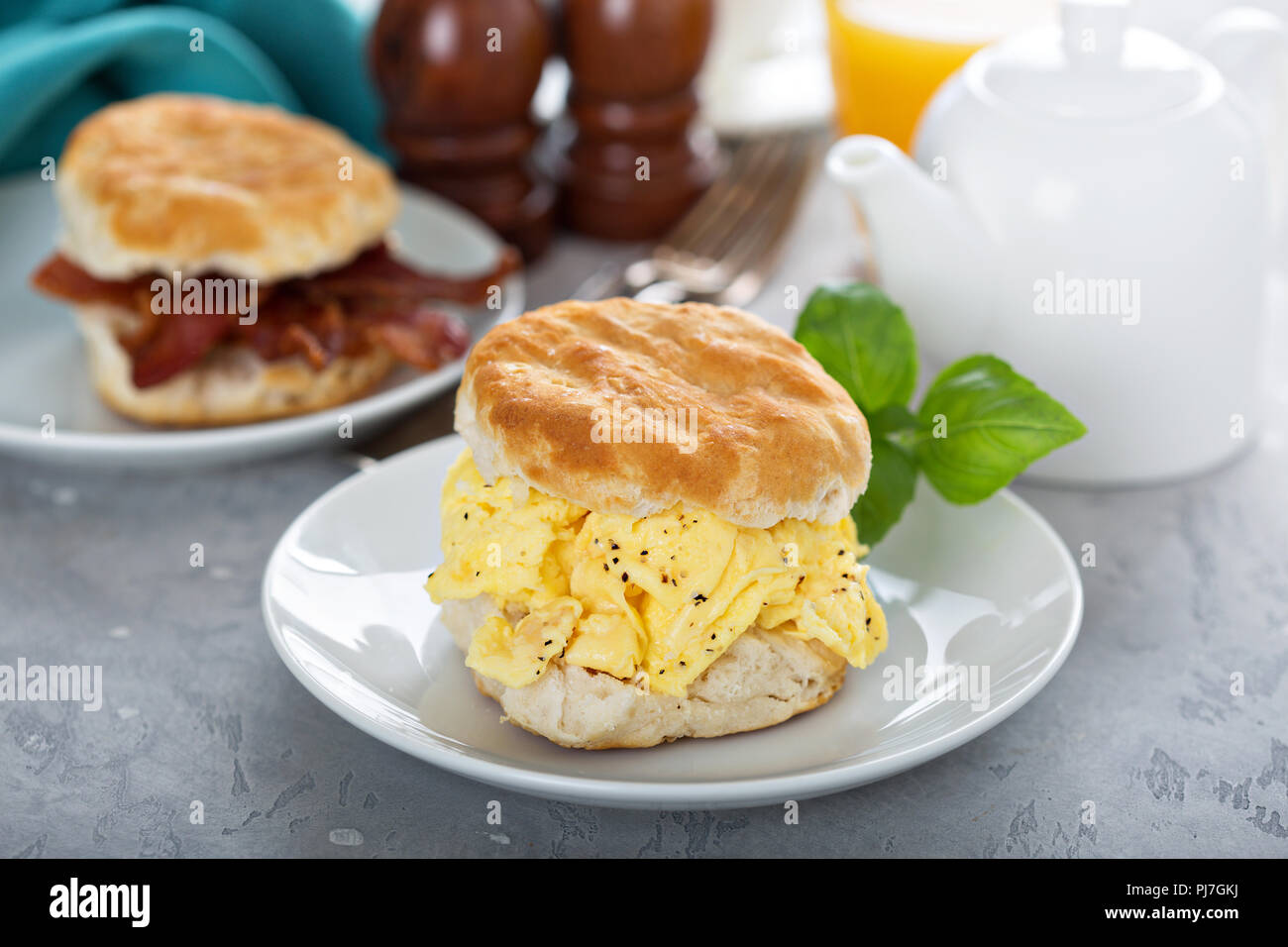 Breakfast biscuits with soft scrambled eggs and bacon on white plate