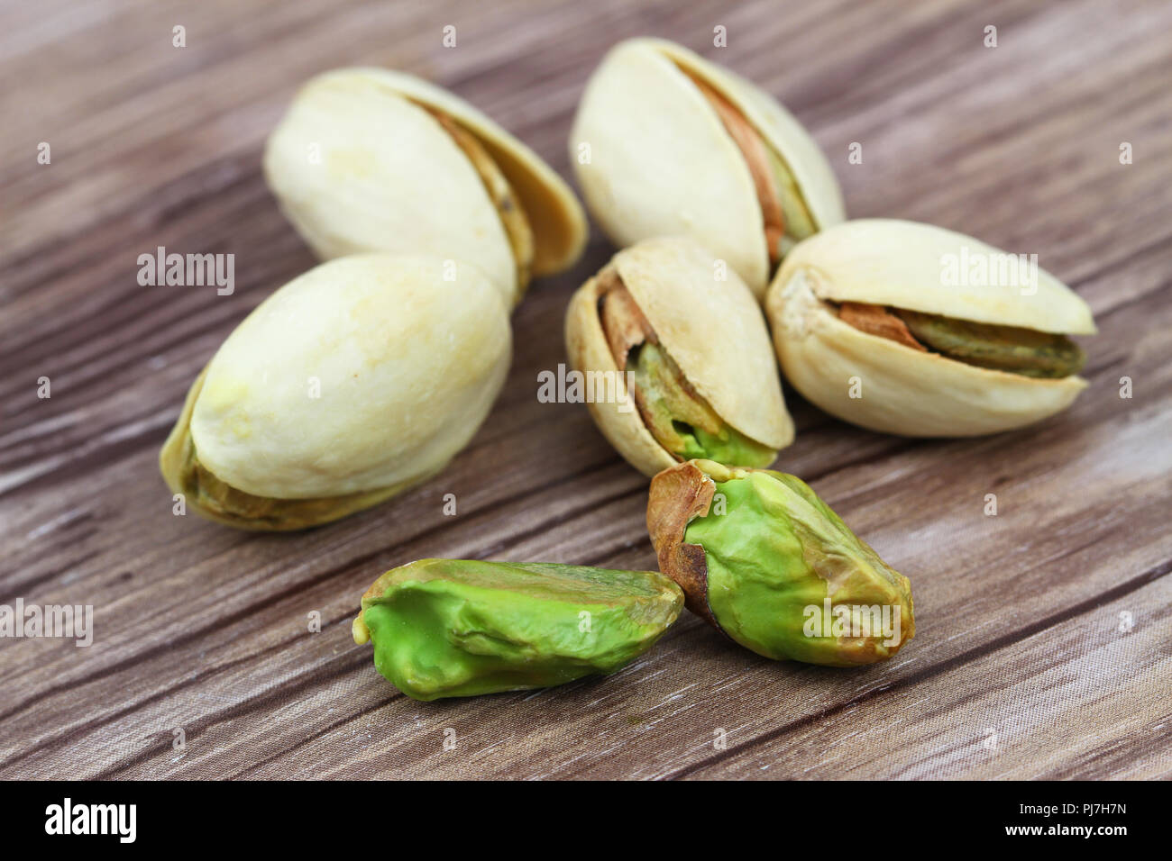 Close up of few pistachios on wooden surface Stock Photo