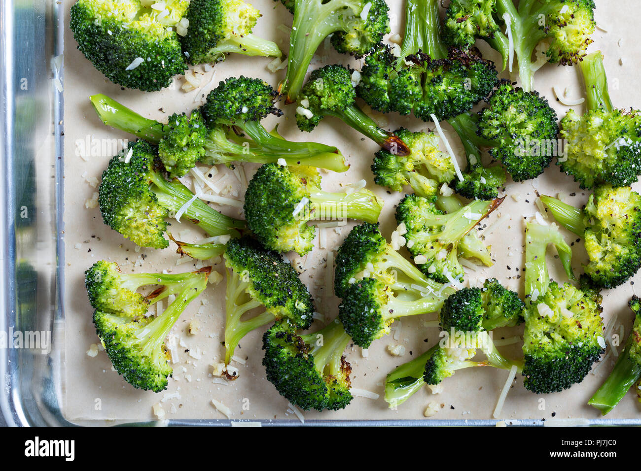 Roasted broccoli florets with cheese on a baking tray Stock Photo