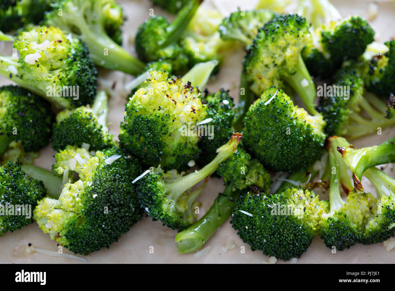 Roasted broccoli florets with cheese on a baking tray Stock Photo