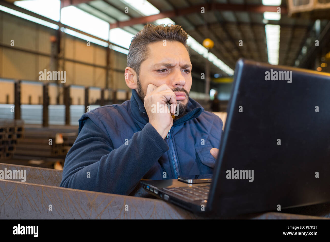 manual worker using a laptop in a warehouse Stock Photo - Alamy