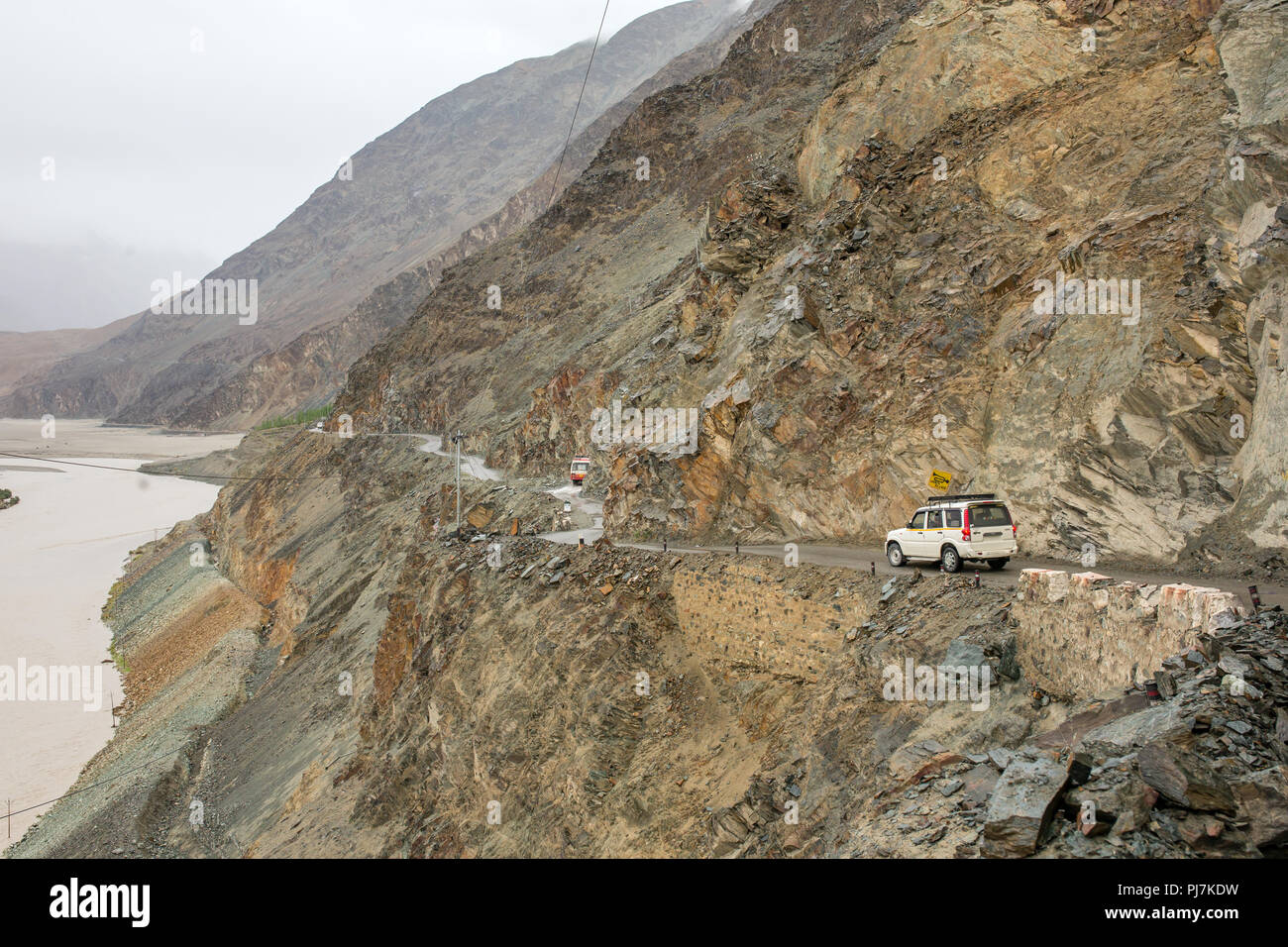 Car driving on dangerous mountain road in Nubra valley surrounded by Himalayas in Ladakh, India Stock Photo