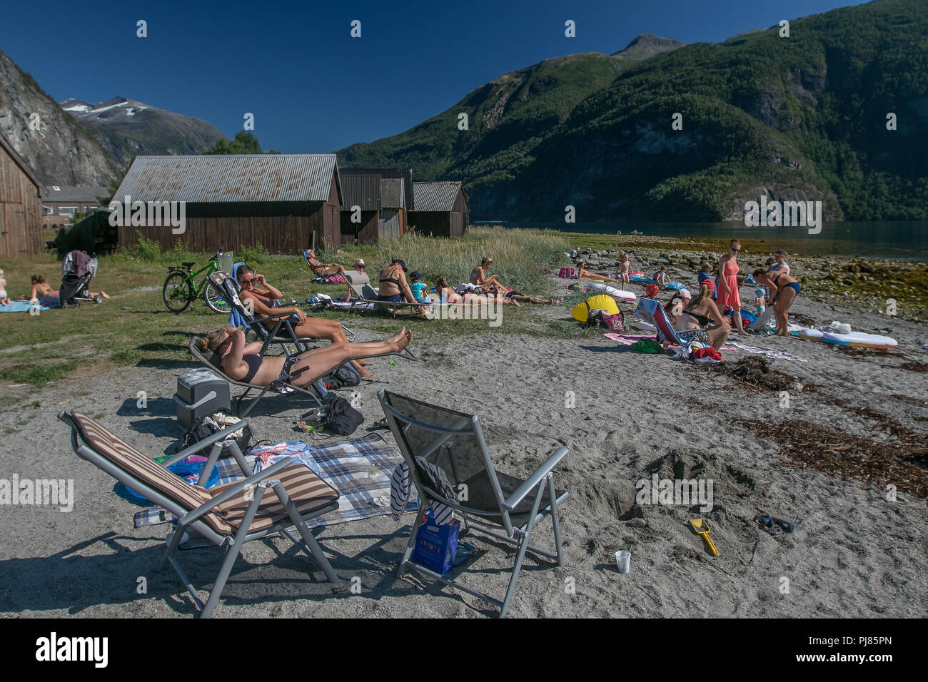 Norway, July 26, 2018: People are sunbathing on a fjord beach on a hot summer day. Stock Photo