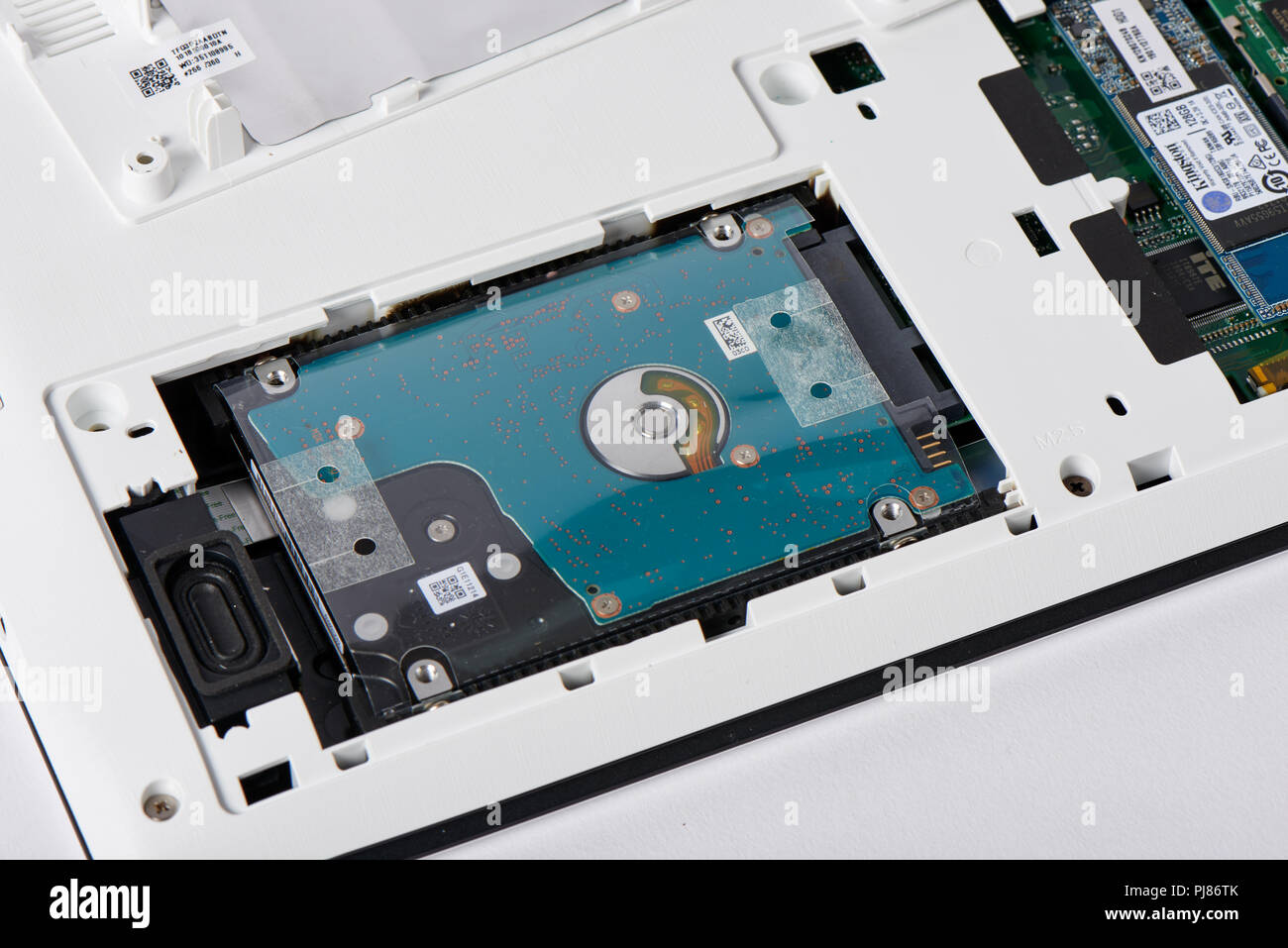 Gimpo-si, Korea - July 10, 2018: 2.5inch hard disk drive with aseembly bracket and SATA slot on the access panel of laptop computer for hardware upgra Stock Photo