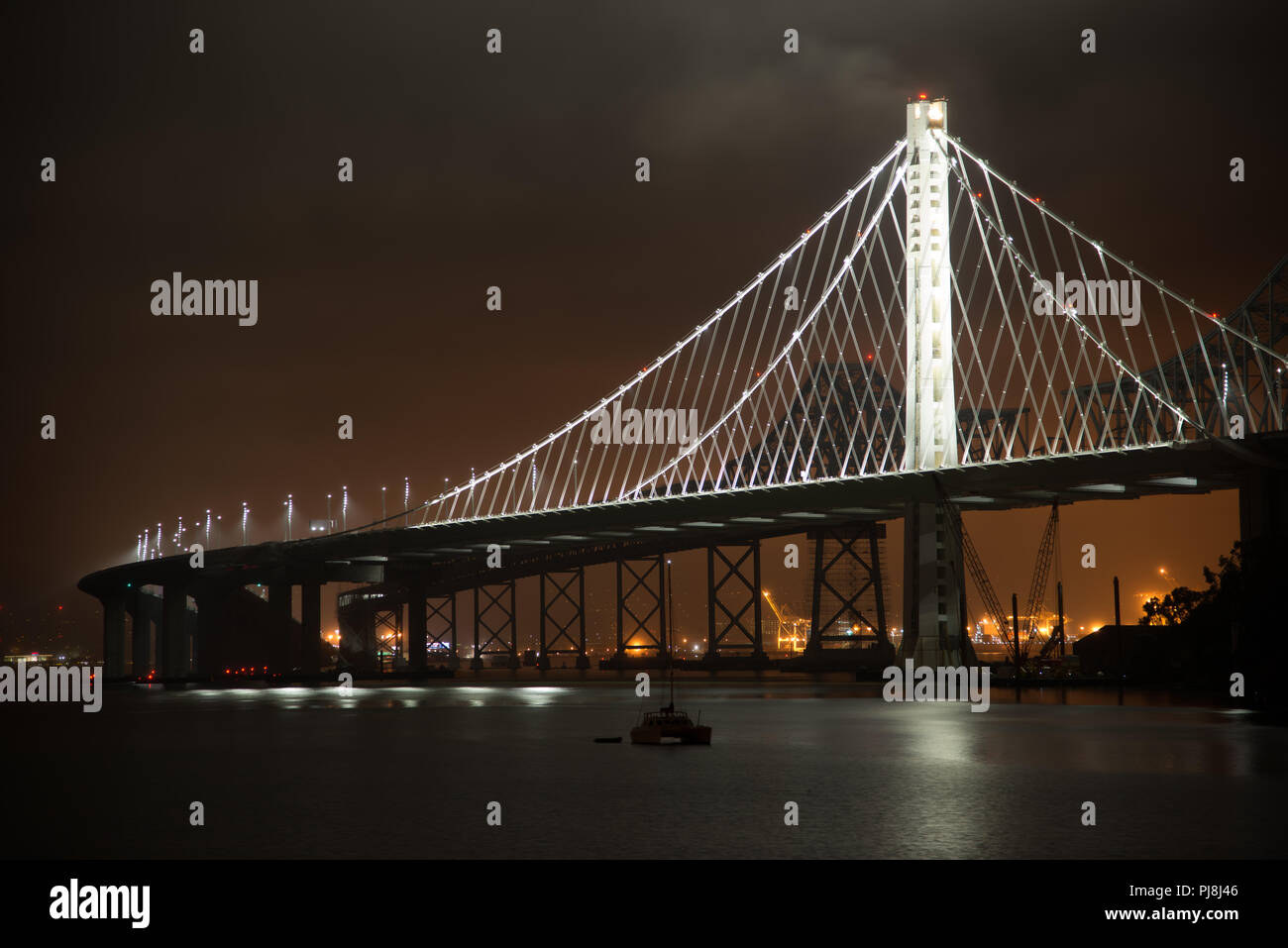 Boats at dock with the Bay Bridge in background at night, San Francisco, North Beach, California, USA Stock Photo