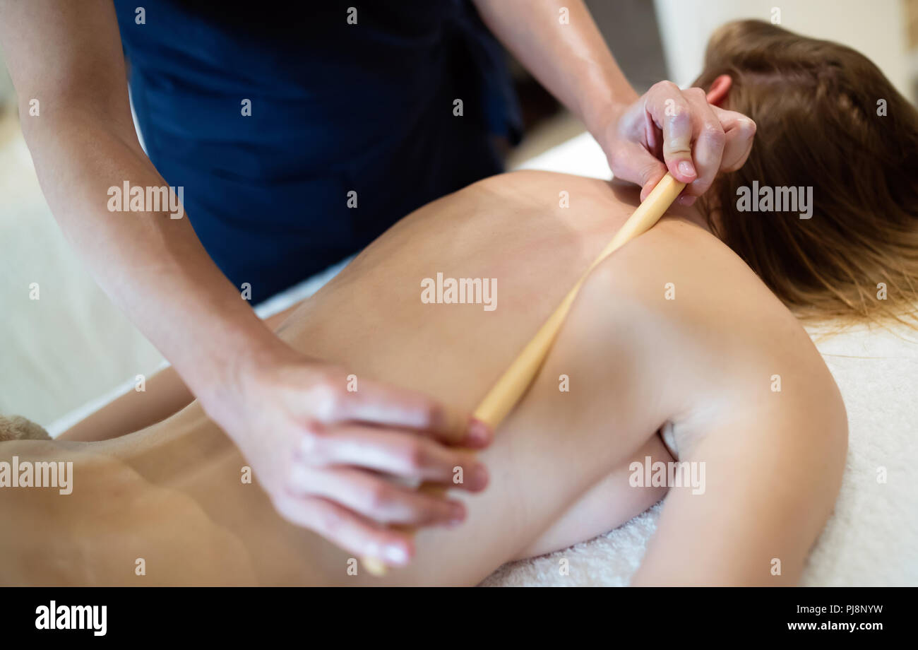 Masseur massaging female on bed Stock Photo