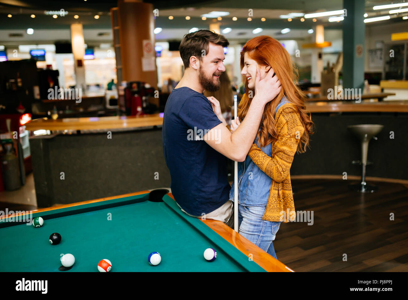 Couple hugging in snooker bar Stock Photo