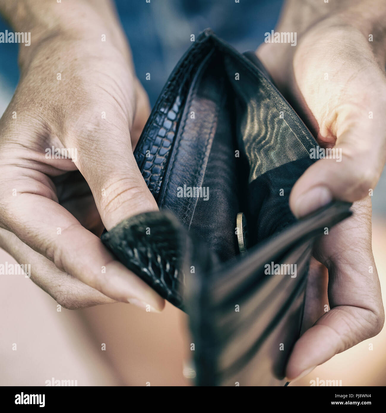 Open purse with one coin inside close-up as a sign of lack of money Stock Photo