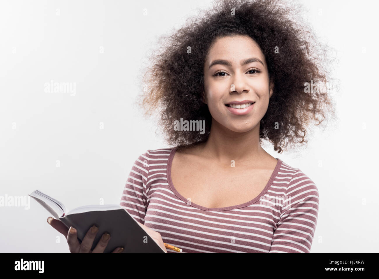 Dark-eyed curly manager feeling curious while working on her new project Stock Photo