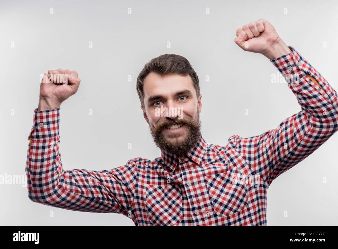 Dark-haired bearded office worker feeling happy after finishing project ...