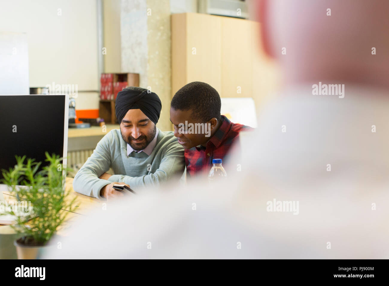 Businessmen using smart phone in office Stock Photo