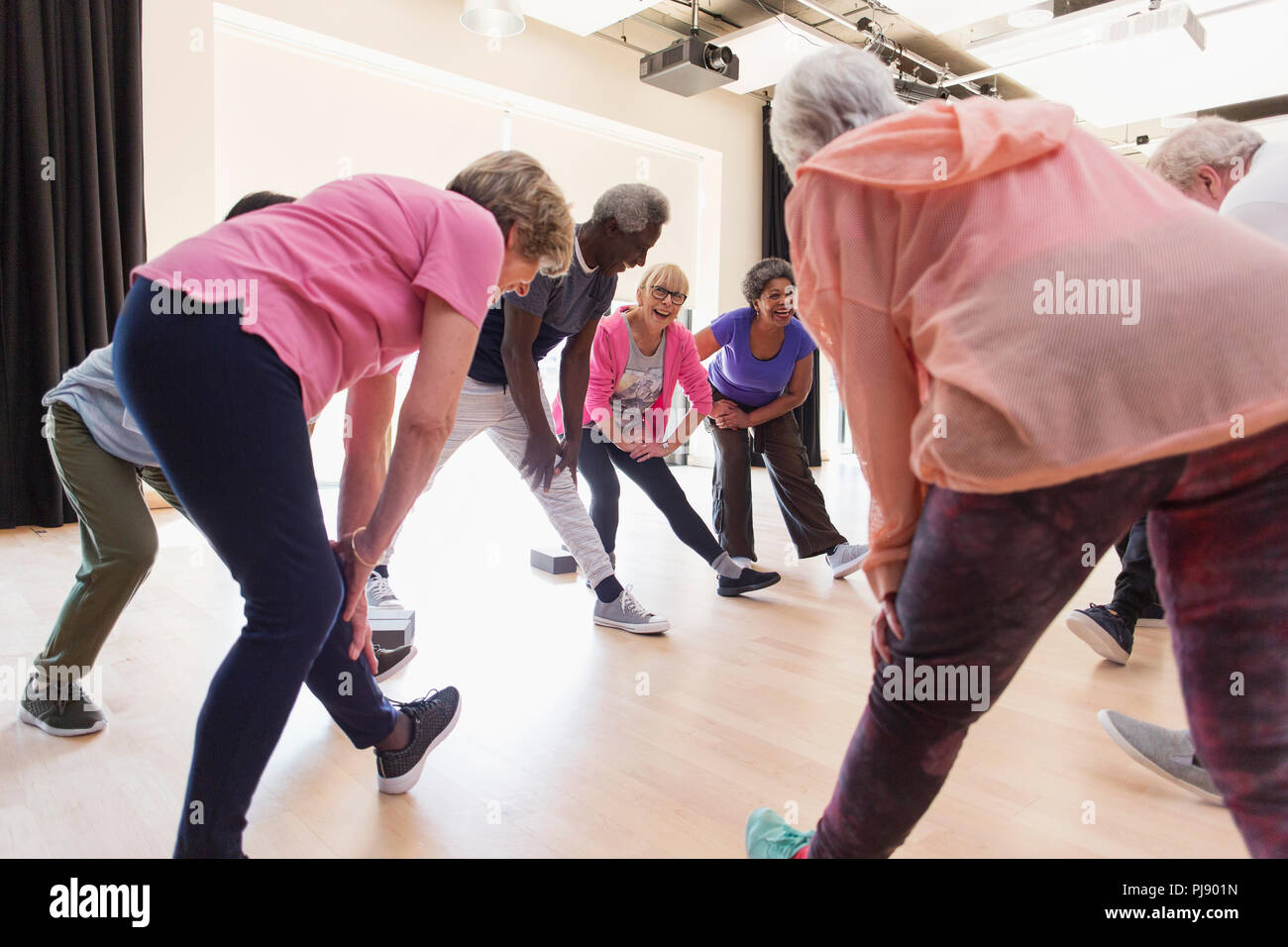 Active seniors stretching legs in exercise class Stock Photo