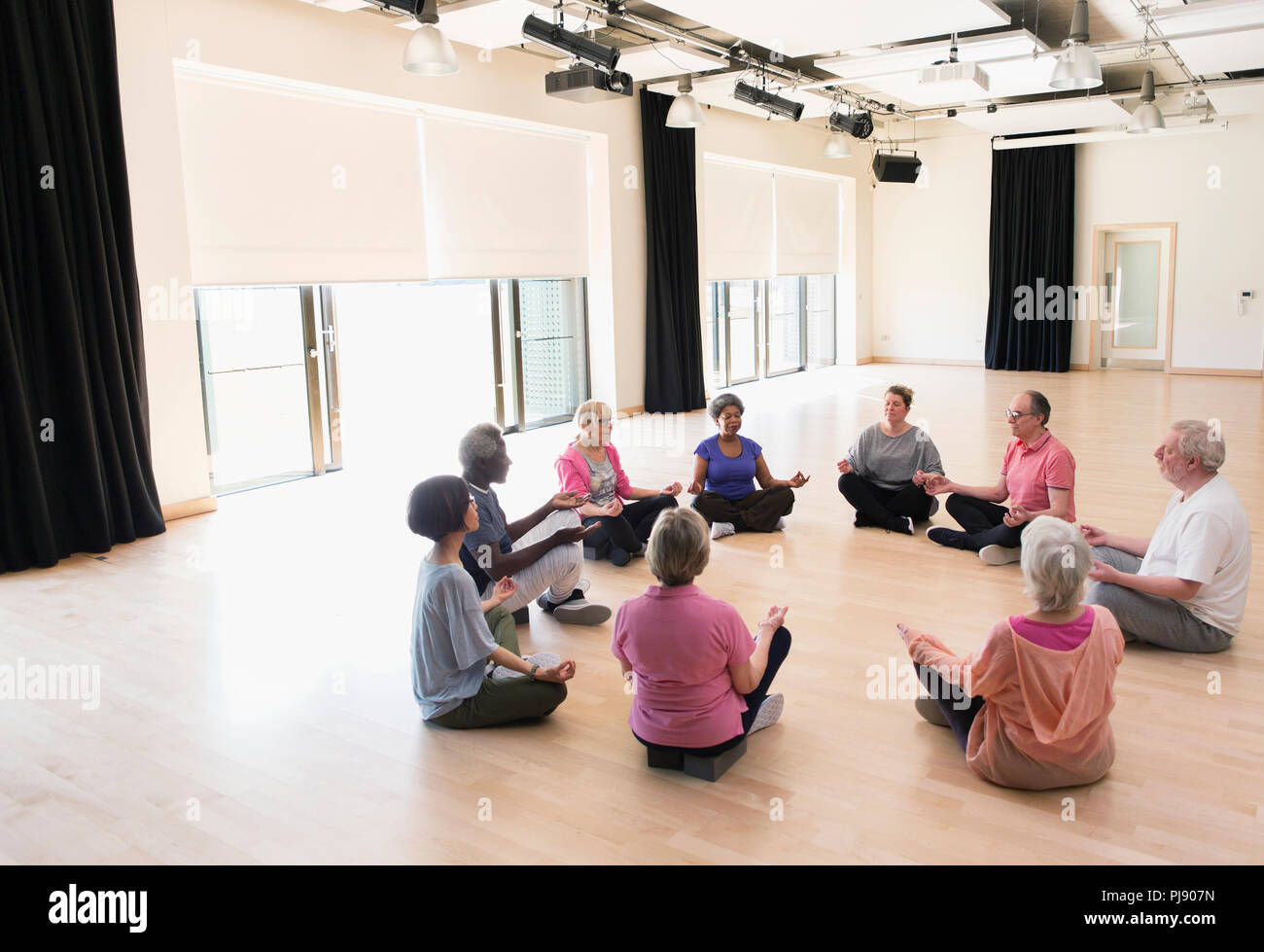 Serene active seniors meditating in circle Stock Photo