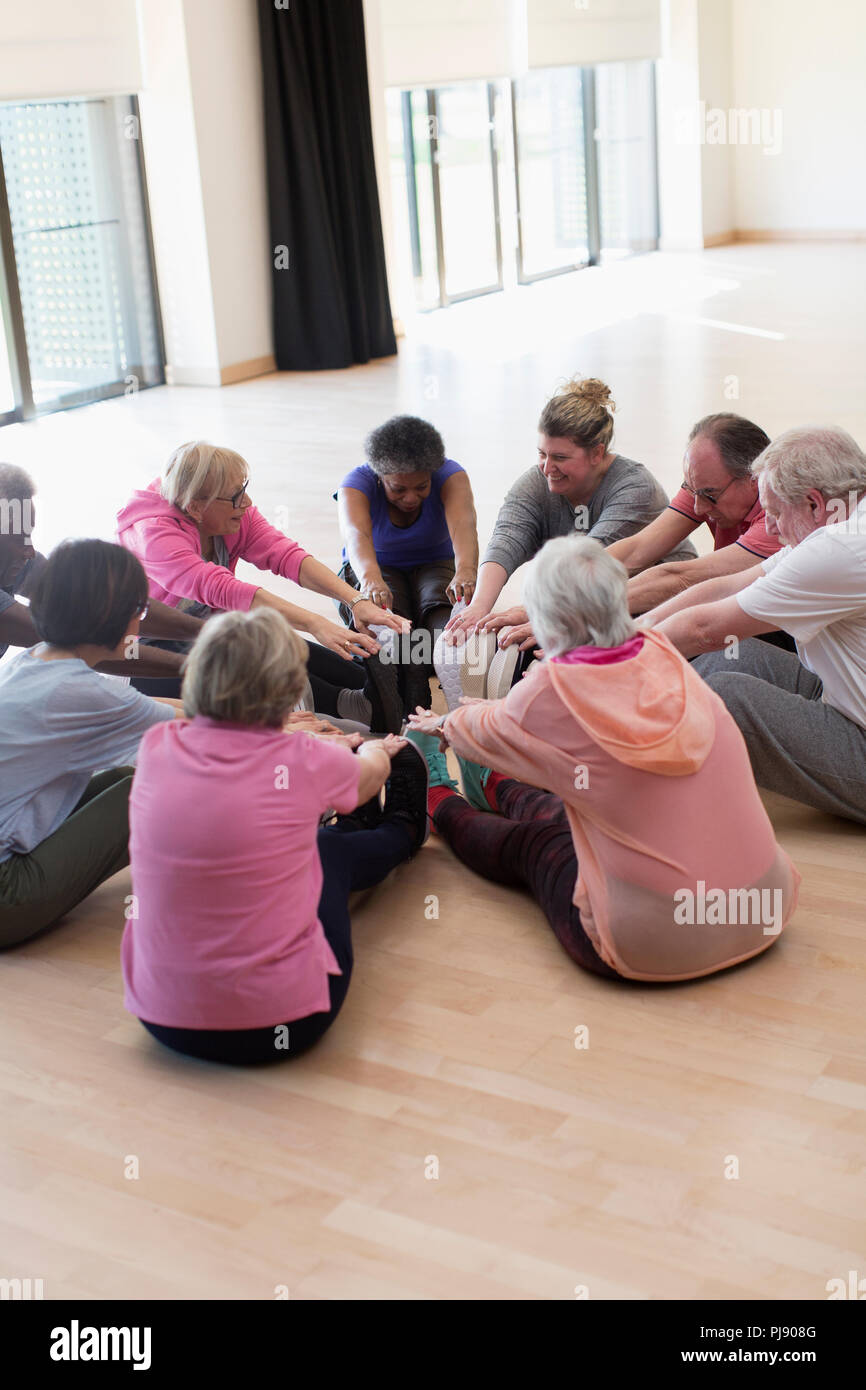Active seniors stretching legs in circle Stock Photo