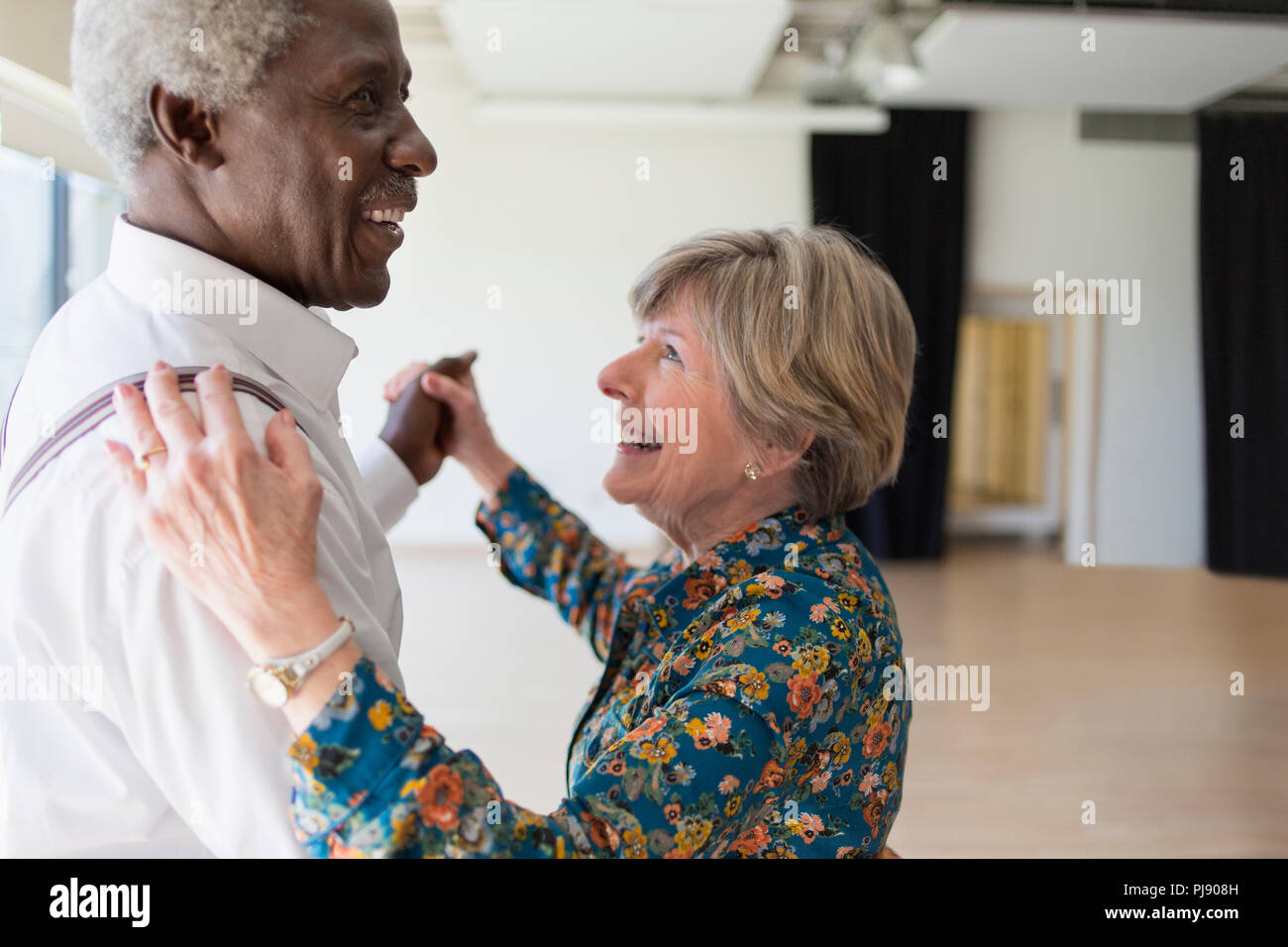Happy active senior couple dancing in dance studio Stock Photo