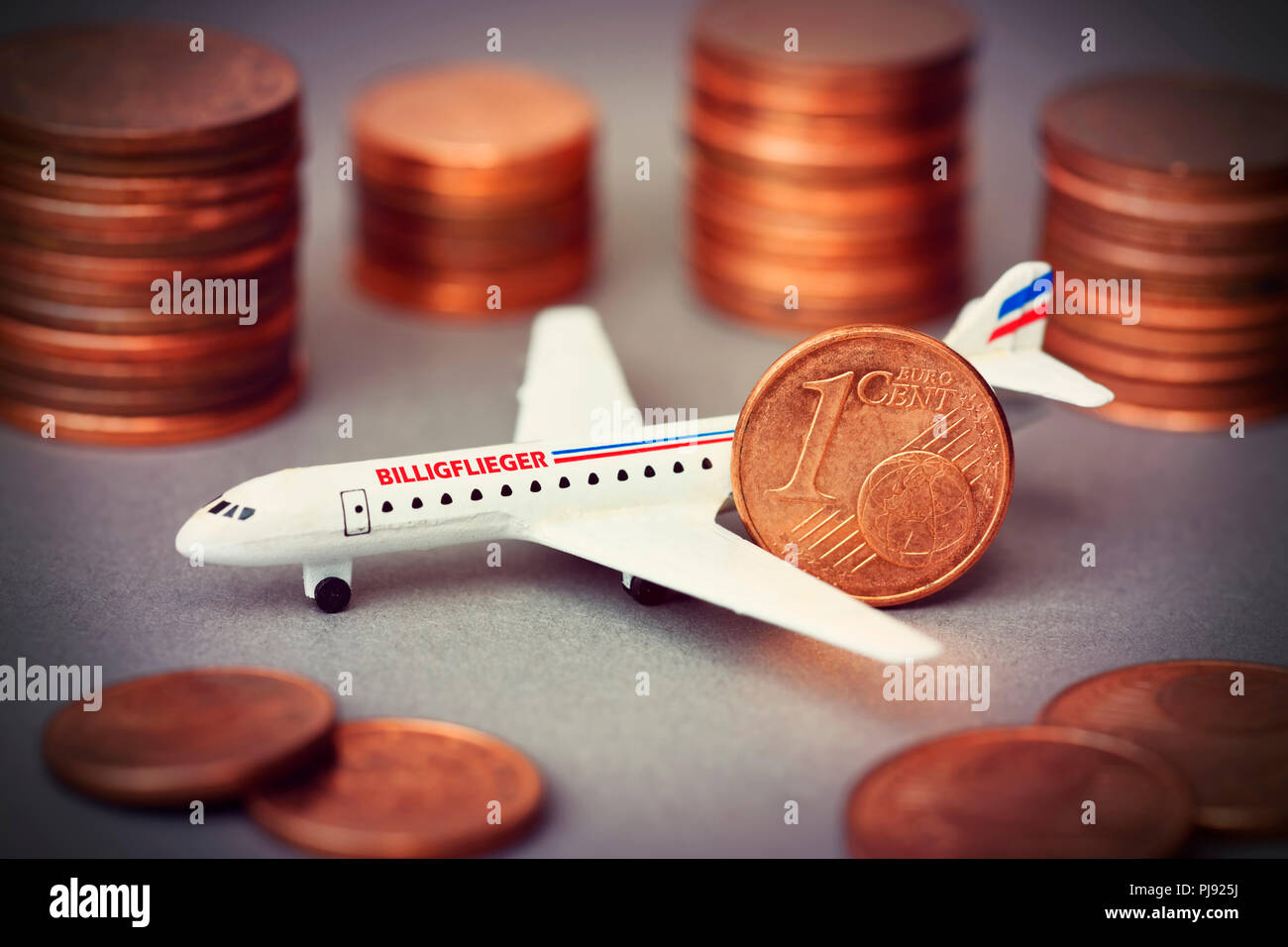 Miniature airplane with label Cheap airman and cent coins, Miniaturflugzeug mit Aufschrift Billigflieger und Centmünzen Stock Photo