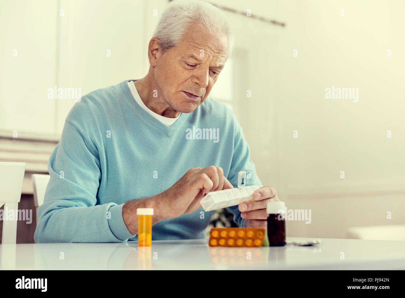 Depressed senior gentleman taking pills Stock Photo