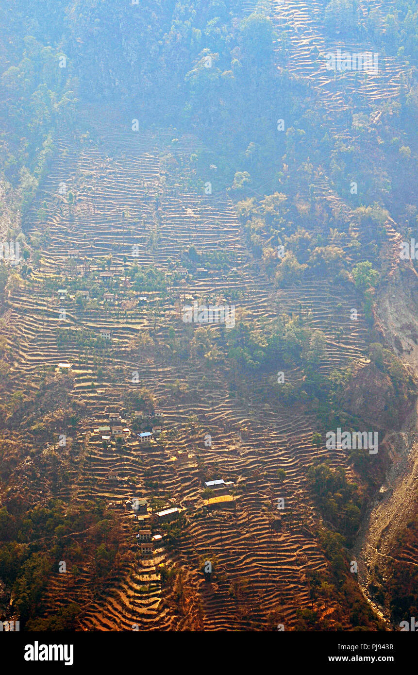 Houses dot a steep, terraced hillside in the Solukhumbu region, Nepal Stock Photo
