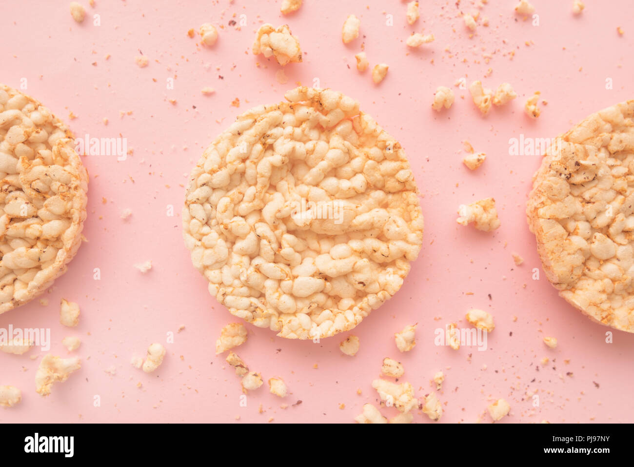 Flat lay crunchy rice cakes on pastel pink background, overhead top down view Stock Photo
