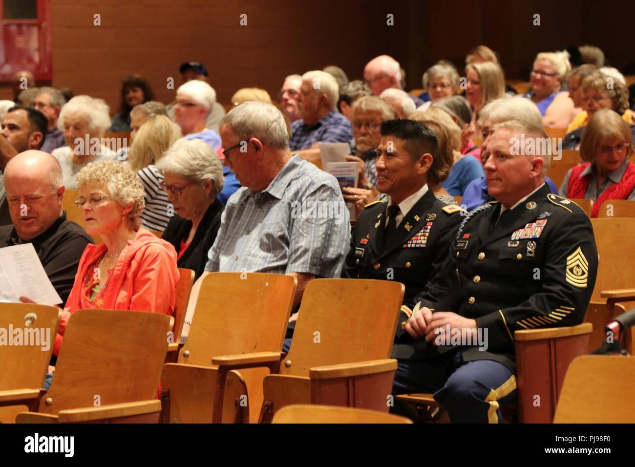 Col. Neal S. Mitsuyoshi, Commander of 103rd Troop Command, and Command Sgt. Maj. Thomas Odoardi of 103rd Troop Command arrive as guests to the joint concert of the 111th Army Band and 234th Army Band at Astoria High School in Astoria, Oregon, July 7, 2018. The concert is the second collaboration between the 111th Army Band and the 234th Army Band with efforts to display the results of their training in a live setting. Stock Photo