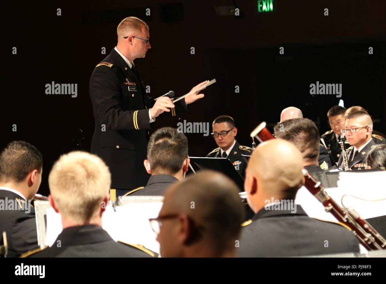 Chief Warrant Officer Three Ashley Alexander, Commander of the 234th Army Band guides the 111th Army Band and 234th Army Band through a song during their performance at Astoria High School in Astoria High School in Astoria, Oregon, July 7, 2018. The concert is the second collaboration between the 111th Army Band and the 234th Army Band with efforts to display the results of their training in a live setting. Stock Photo