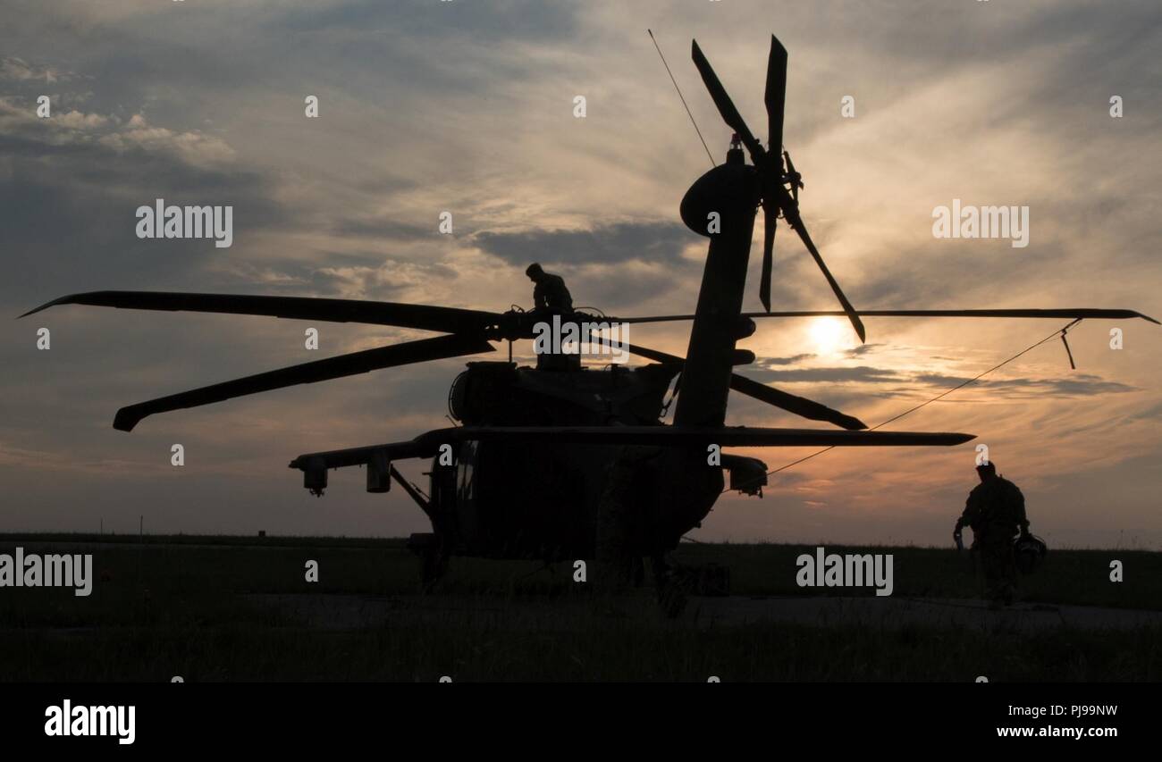 U.S. Soldiers assigned to the 2nd General Support Aviation Battalion, 4th Aviation Regiment, 4th Combat Aviation Brigade, 4th Infantry Division, conduct safety checks and prepare their UH-60 Blackhawk for air assault training at Mihail Koglniceanu Air Base, Romania, July 10, 2018. The Soldiers of 2nd GSAB are conducting similar training in multiple locations throughout Europe in support of Atlantic Resolve, a U.S. endeavor to fulfill NATO commitments by rotating U.S.-based units throughout the European theater to deter aggression against NATO allies and partners in Europe. Stock Photo