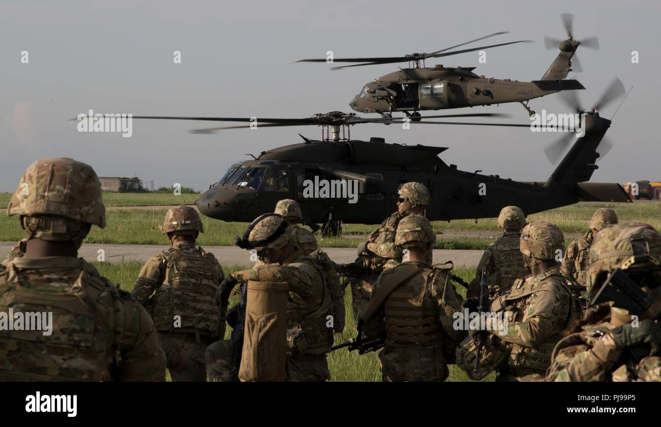 U.S. Soldiers assigned to 2nd Battalion, 5th Cavalry Regiment, 1st Brigade Combat Team, 1st Cavalry Division, stage before loading onto 2nd General Support Aviation Battalion, 4th Aviation Regiment, 4th Combat Aviation Brigade, 4th Infantry Division, UH-60 Blackhawks during air assault training near the Mihail Koglniceanu Air Base, Romania, July 10, 2018. The Soldiers of 2nd GSAB are conducting similar training in multiple locations throughout Europe in support of Atlantic Resolve, a U.S. endeavor to fulfill NATO commitments by rotating U.S.-based units throughout the European theater to deter Stock Photo