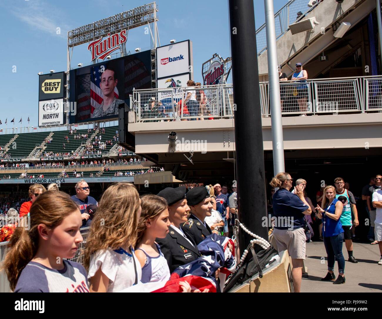 1st Sgt. Katie Blackwell and Staff Sgt. Ashley Meraz prepare to raise the American flag during the 2018 Minnesota Twins Armed Forces Appreciation Day. Blackwell and Meraz are both Purple Heart recipients from the Minnesota Army National Guard. Blackwell received the Purple Heart when she was wounded after her scout vehicle struck an improvised explosive device May 29, 2006, in Baghdad, Iraq. Meraz was wounded after her vehicle drove over a pressure plate improvised explosive device near Forward Operating Base Leatherneck in Afghanistan, October 7, 2009. Her driver, Spc. George Cauley, was kill Stock Photo