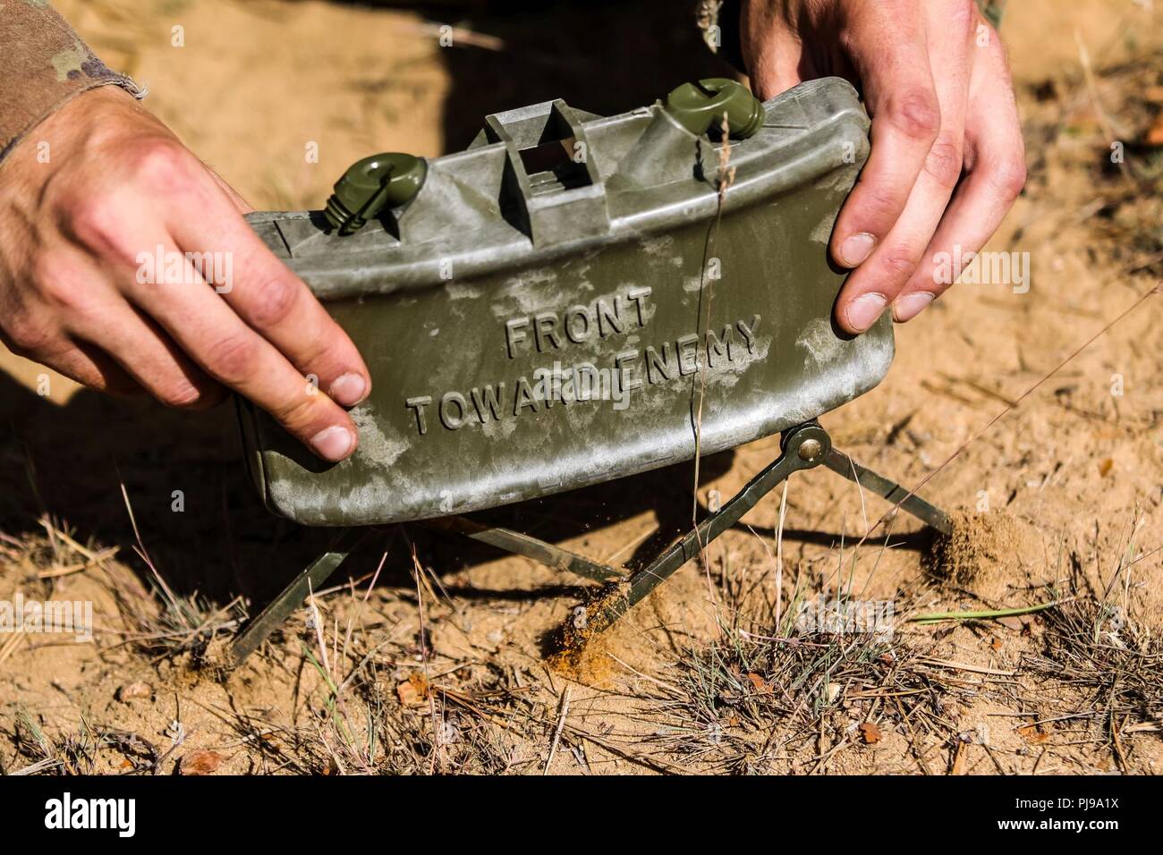 U.K. Army Sgt. Rob Veasey with 1st The Queen's Dragoon Guards, emplaces a M18A1 Claymore mine during a multinational claymore training exercise with Battle Group Poland at Bemowo Piskie Training Area, Poland on July 10, 2018. Battle Group Poland is a unique, multinational coalition of U.S., U.K., Croatian and Romanian Soldiers who serve with the Polish 15th Mechanized Brigade as a deterrence force in support of NATO’s Enhanced Forward Presence. Stock Photo