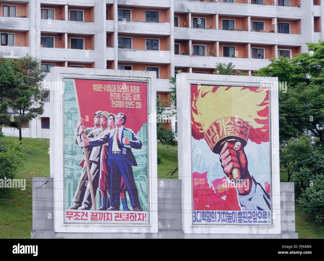 Heroic motivational propaganda posters dominate a Pyongyang street, North Korea Stock Photo