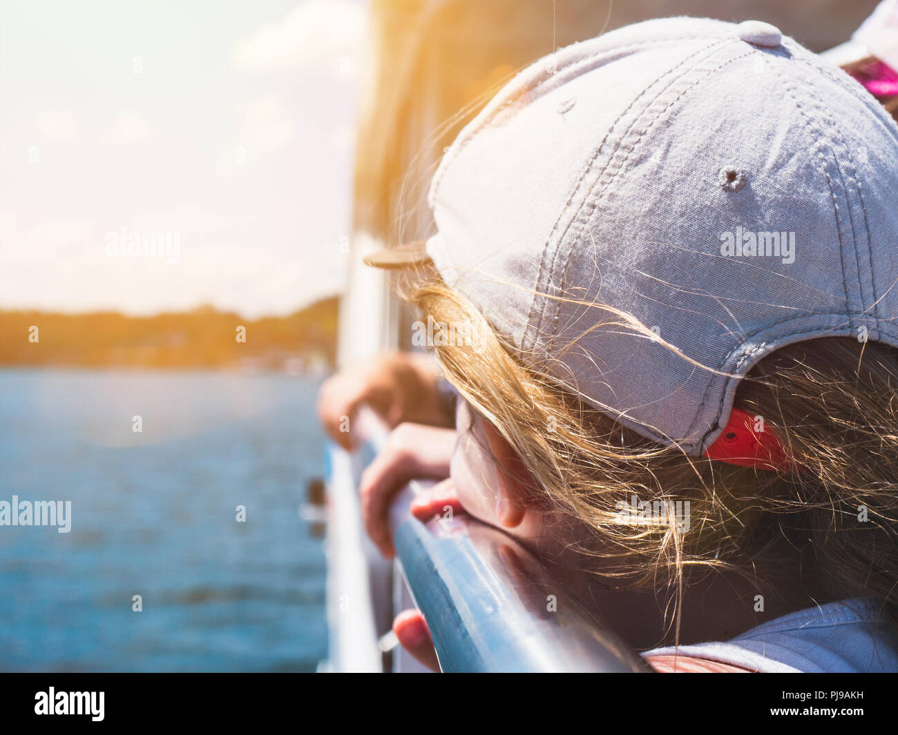 Vacations: Little Girl Looking over Lake Constance while standing on a boat Stock Photo