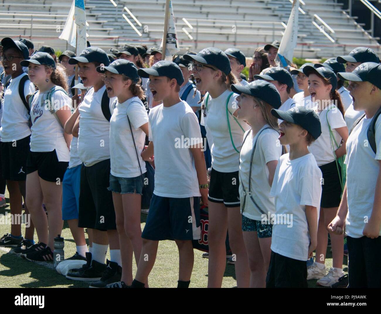 BOSTON – Junior Police Academy cadets from Malden, Massachusetts get motivated at Dillboy Stadium in Somerville, Massachusetts before the Guard Fit Challenge there July 12, 2018. The Massachusetts National Guard and police departments from Everett, Malden and Somerville used the physical fitness program as a way to encourage engagement between public safety officials and young people. (Massachusetts National Guard Stock Photo