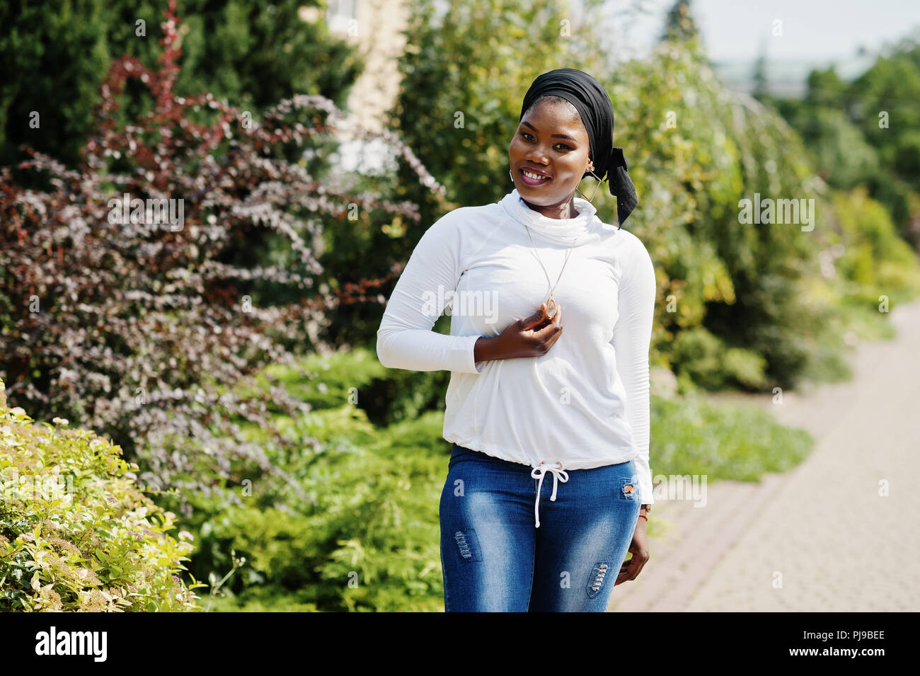 African muslim girl in black hijab, white sweatshirt and jeans posed  outdoor Stock Photo - Alamy