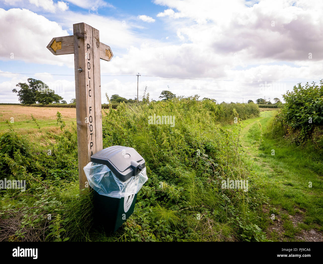 A wooden signpost marks the route along an offroad footpath in