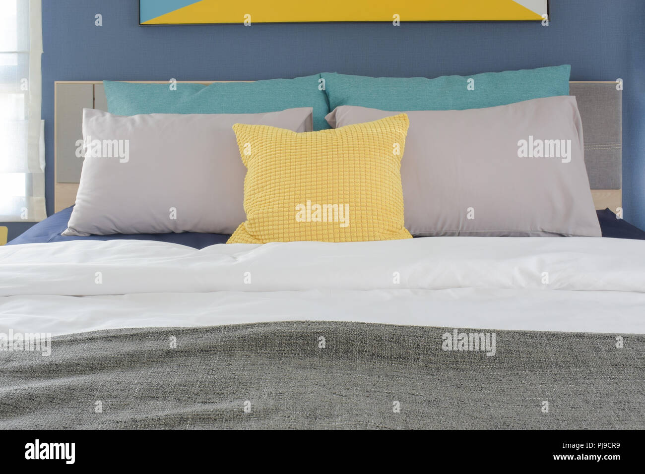 Yellow Gray And Turquoise Color Pillows Setting On Bed In
